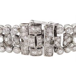 Art Deco platinum diamond and ruby bracelet, circa 1920-1930, the central panel set with a single emerald cut diamond of approx 0.55 carat, flanked by two baguette cut diamonds and old cut diamond surround, the articulated geometric design bracelet with vari-cut rubies, round and baguette cut diamonds, total diamond weight approx 7.00 carat, in Mappin & Webb silk and velvet lined box