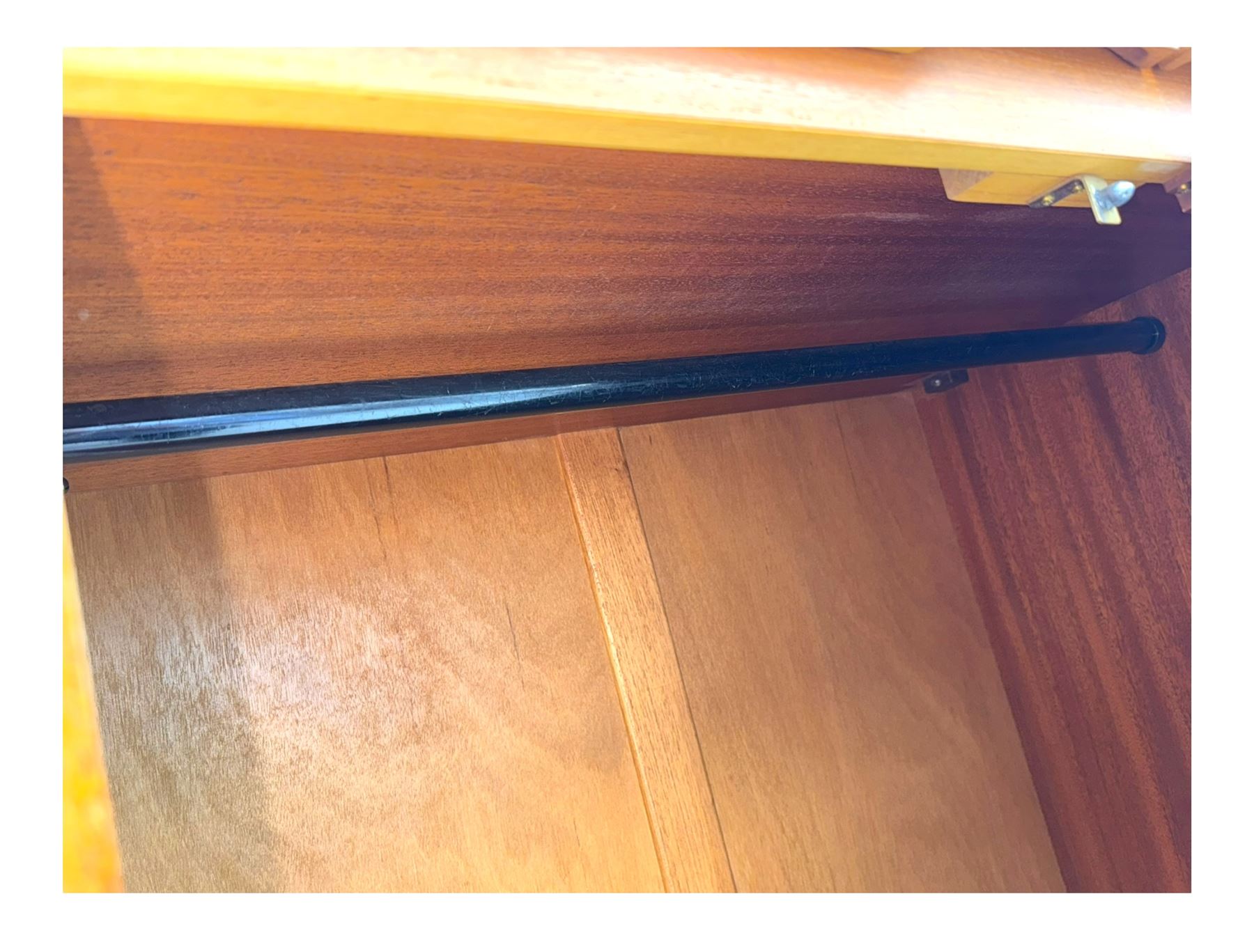 William Lawrence - mid-20th century teak double wardrobe, upper storage section over twin doors featuring recessed handles and contrasting horizontal panel, enclosing a hanging rail compartment, on plinth base with concealed castors