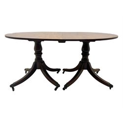 Georgian design mahogany twin pedestal dining table, oval top with reeded edge, single additional leaf, on turned pedestal with four out splayed supports, cast brass hairy paw castors 