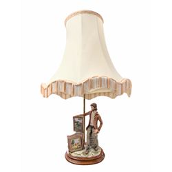 Capodimonte figural table lamp, modelled as an artist showcasing his work, with fabric tassel shade, H70cm