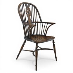 Late 19th century elm and beech high back Windsor armchair, the arched hoop back centred by a pierced wheel splat above a heart shaped lower piercing, with turned spindles and shaped arm rail, saddle seat, raised on turned legs united by a crinoline stretcher