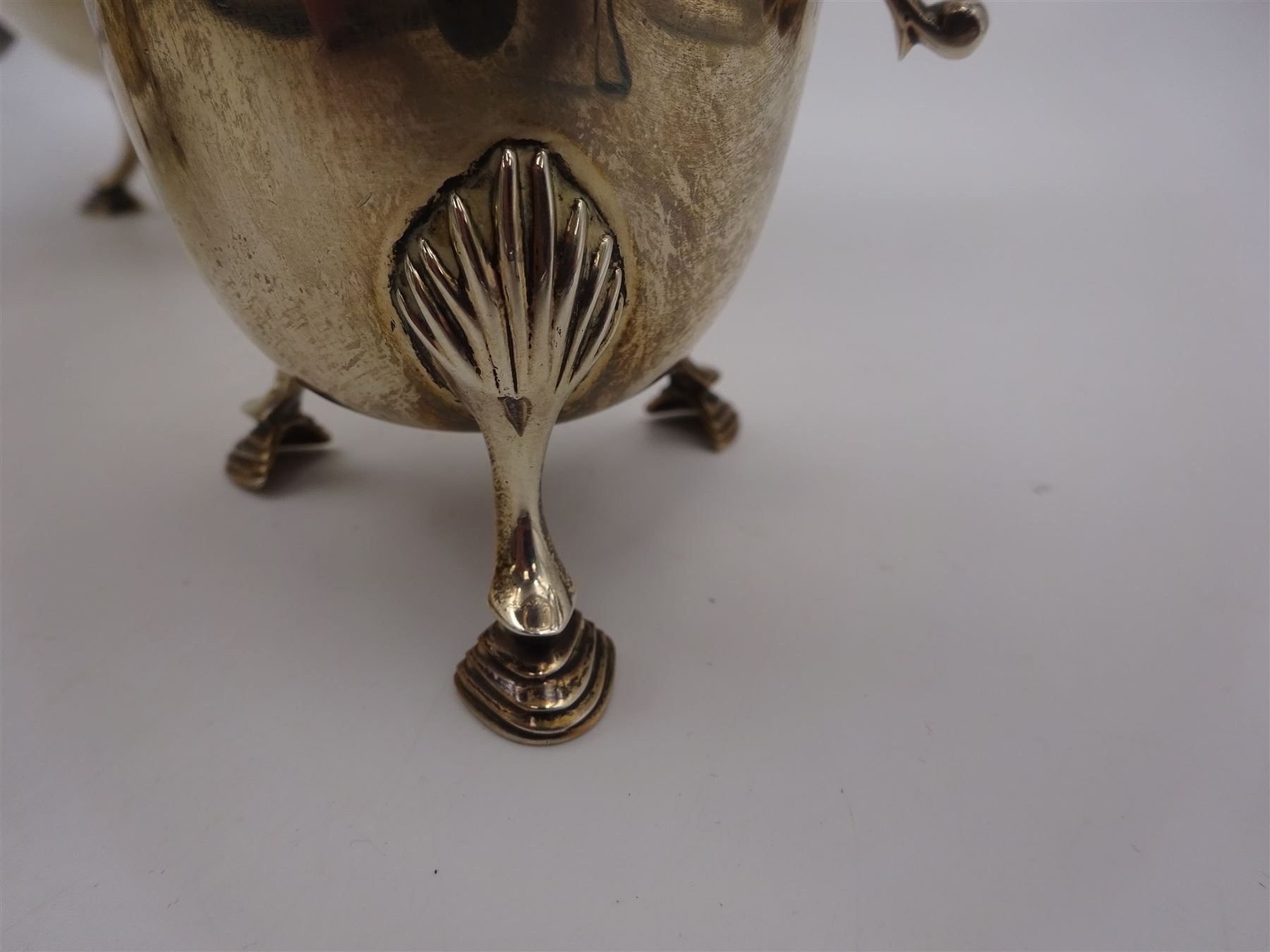 1920s three piece silver tea service, comprising teapot, with ebonised wooden handle and finial, milk jug and open sucrier, all of circular form, with shaped rims, and upon three hoof feet, hallmarked Wakely & Wheeler, London 1922, teapot H19cm