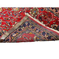 Central Persian Kashan crimson ground runner rug, the field decorated with interlacing branch and stylised flower head motifs, the guarded indigo border with repeating trailing foliate patterns