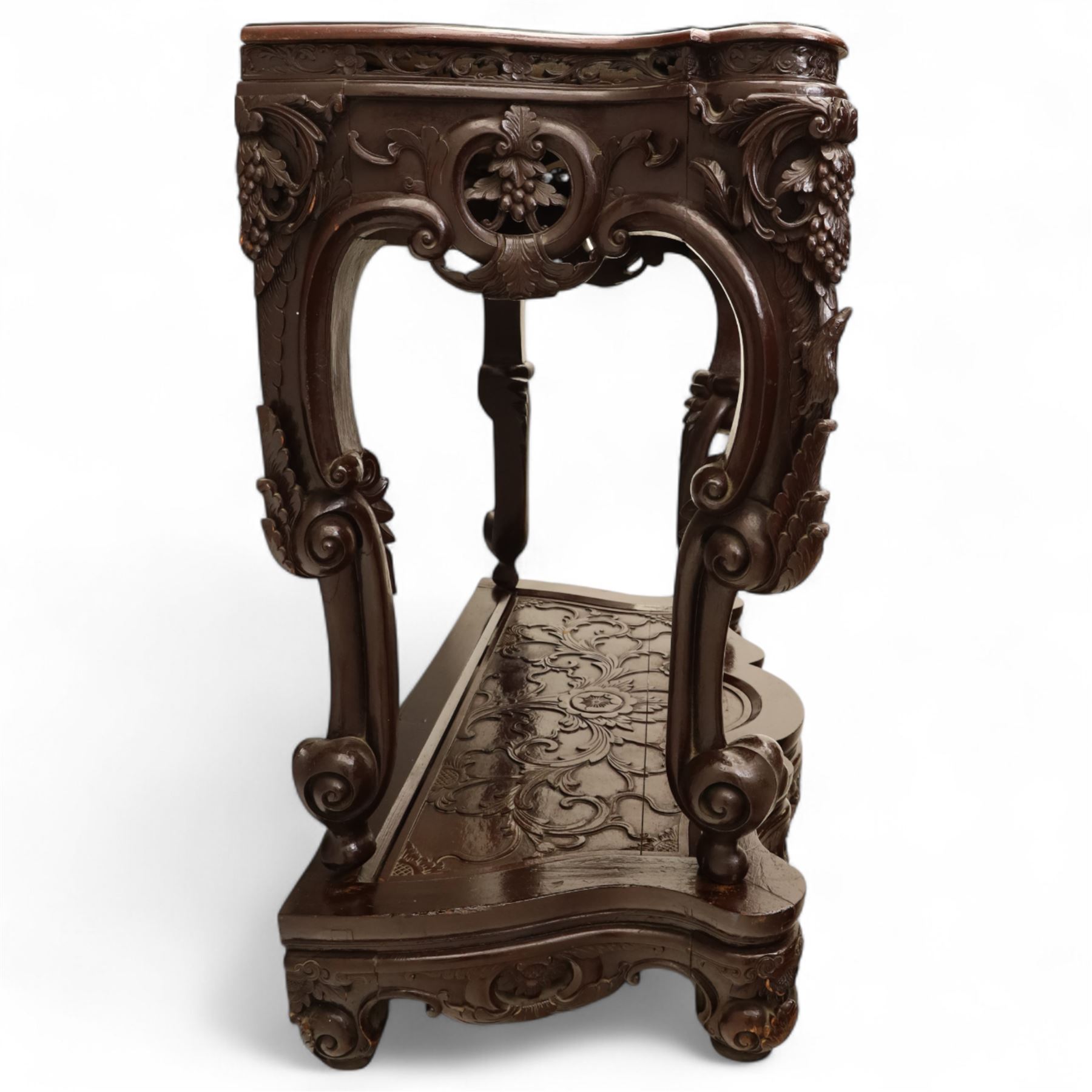 Chinese stained hardwood side table, late Qing dynasty style, with shaped top above a pierced and carved frieze of foliage and fruiting vines, cabriole legs terminating in scroll feet, united by a carved shaped undertier