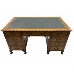 Early to mid 20th century mahogany twin pedestal desk, the rectangular top with gadroon carved edge and leather inset, on two panelled pedestals, fitted with nine drawers, on ball and claw carved feet