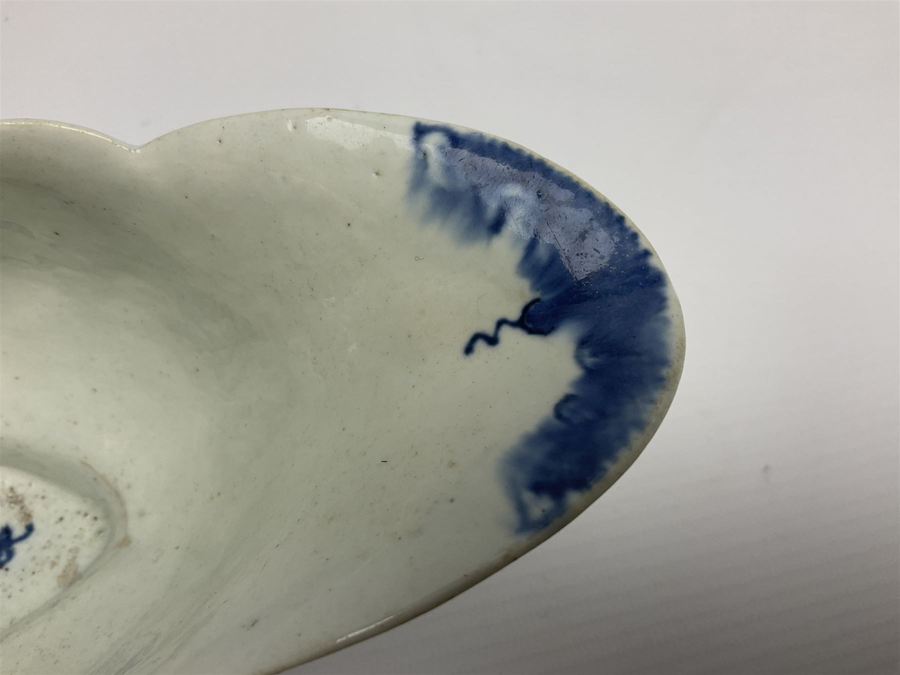 Large 18th century Lowestoft sauce boat, circa 1770, the body decorated with Hughes type floral moulding, and painted in underglaze blue with an Oriental landscape, and foliate sprigs, L23cm