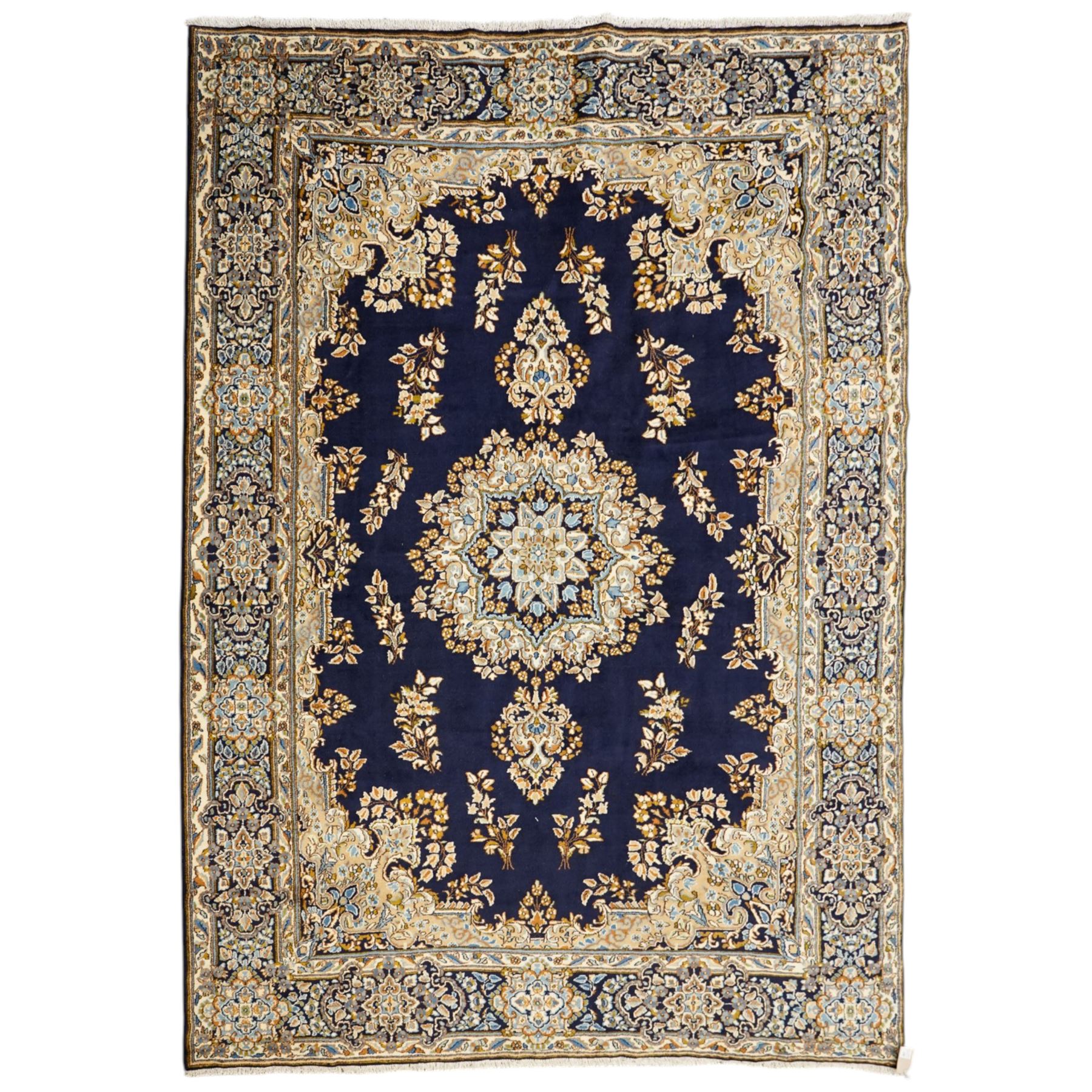 South East Persian Kirman hand-knotted carpet, indigo blue field with central floral medallion in tones of ivory, indigo,  and soft blue, issuing network of scrolling vinery, palmettes and floral sprays, conforming spandrels, broad main border of scrolling foliage and stylized palmettes, framed by multiple guard borders, with cotton fringe ends 
