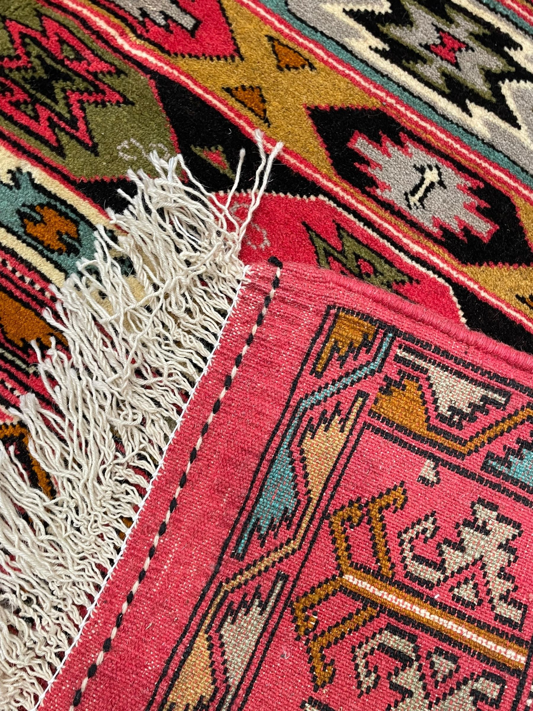 Persian red ground rug, the field divided into horizontal rows and decorated with geometric motifs, intricately pattern borders and end panels