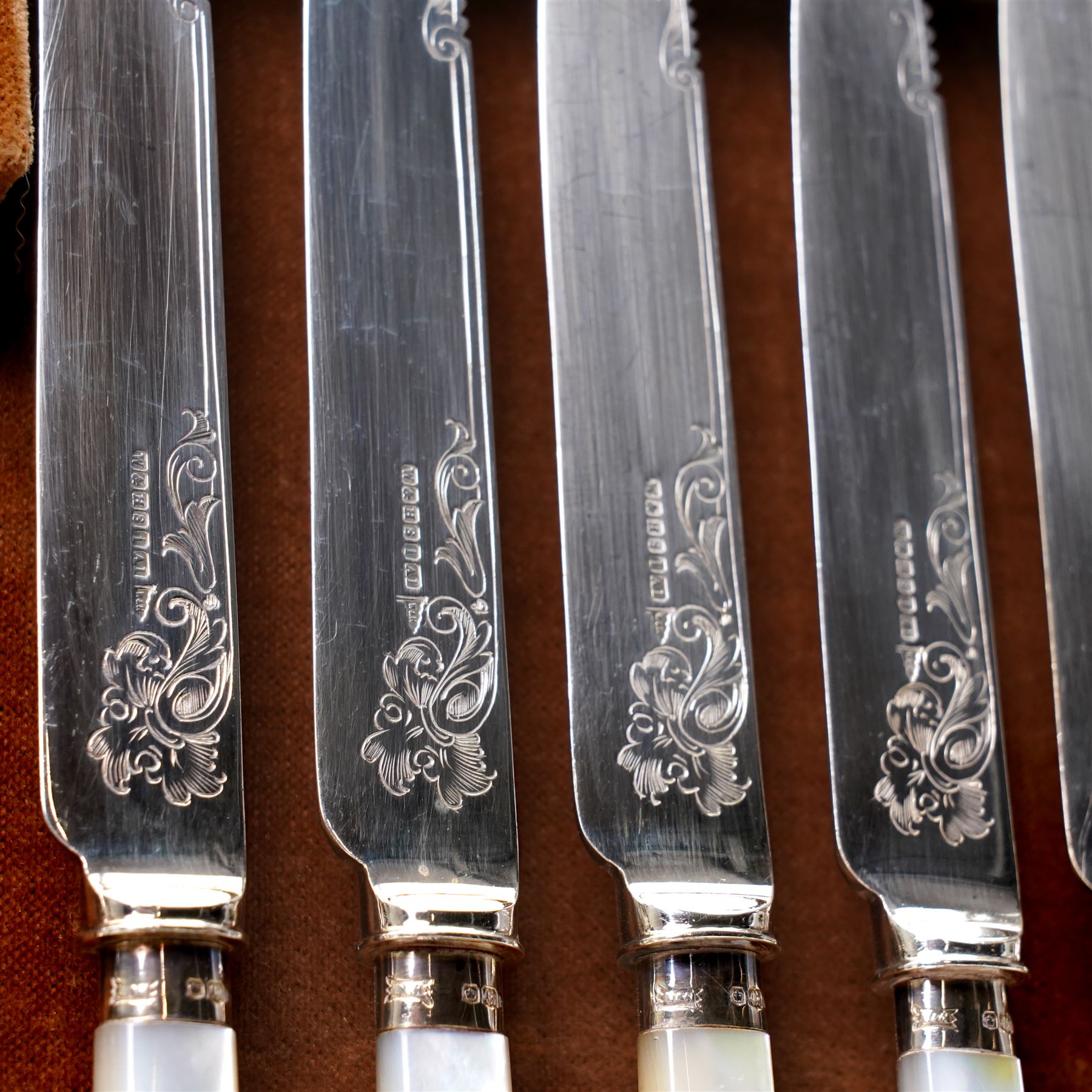 Set of twelve dessert knives and forks with engraved plated blades, silver collars and mother of pearl handles by Walker & Hall in oak box Sheffield 1927 and a set of twelve plated fish knives and forks with servers, boxed