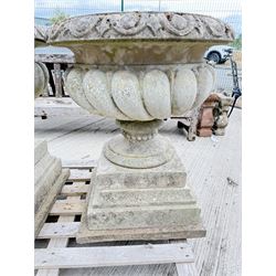 Pair of large weathered Country House Haddonstone garden urns, acanthus carved rim above gadrooned bowl, beaded detailing to the neck, raised on stepped double plinth base
