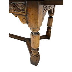 Early 20th century Jacobean design draw-leaf oak dining table, rectangular top with carved frieze depicting scrolling foliage and grape clusters, sliding extending leaves, raised on robust turned supports united by H-stretcher  