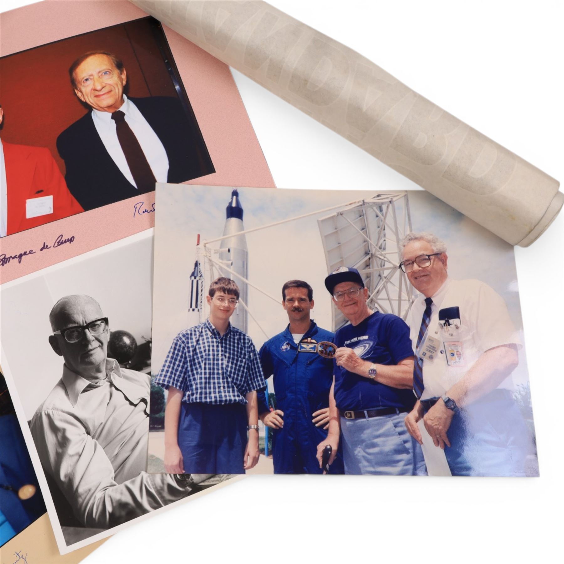 Collection of ephemera relating to Arthur C Clarke, including colour photograph of Arthur with author Joe Green, Jay Kubica and astronaut Chris Hadfield at NASA Kennedy Space Centre, Kennedy Space Centre pennant flag, colour photographs of authors Sam Moskowitz with Forrest Ackerman and L. Sprague de Camp with Robert Bloch, all signed below by the authors, a black and white photograph of Arthur for his 13-Part ITV series 'Arthur C Clarke's Mysterious World', Pan Books cardboard advertisement for Rendezvous with Rama and an Evening Standard poster for The Other Side of the Sky

Notes: This item is from the private collection of Arthur C. Clarke's brother.