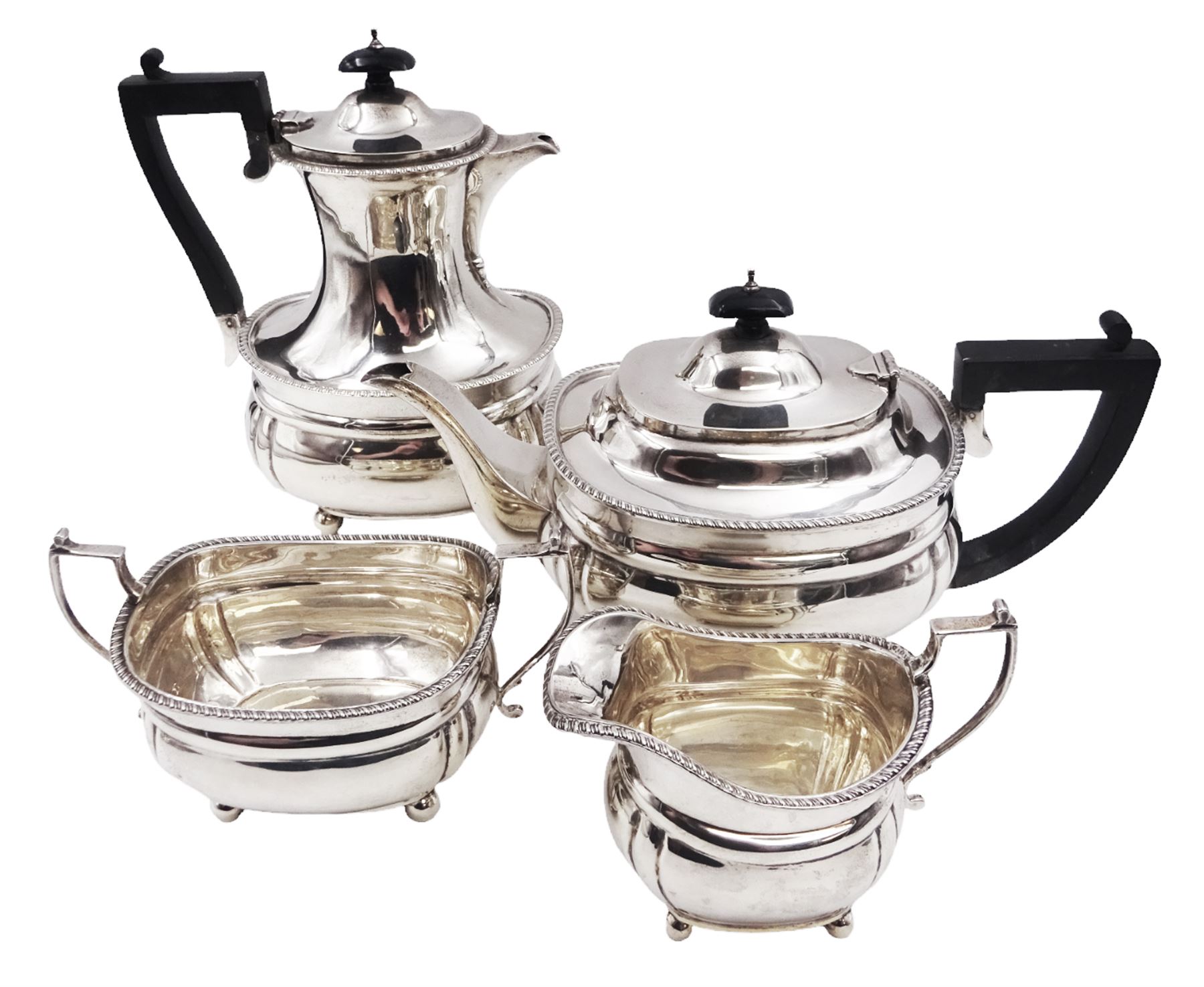 1920s four piece silver tea service, comprising teapot, coffee pot, milk jug and open sucrier, each of bellied form with oblique gadrooned rim and girdle, the teapot and coffee pot with Bakelite style handles and finials, each upon four bun feet, hallmarked Mappin & Webb Ltd, London 1925, coffee pot H22.5cm