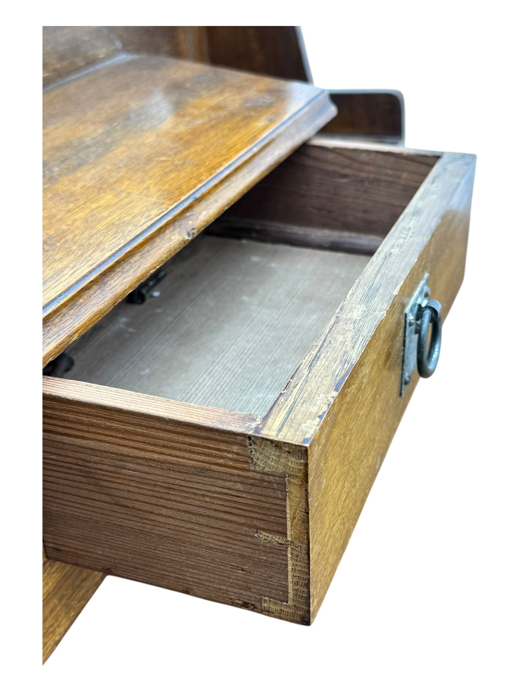 Early 20th century Arts and Crafts oak dressing chest, the arched mirror flanked by floral marquetry inlaid uprights above a shelf and drawer, over three long drawers with square hammered metal plates and circular pulls, on slender supports with castors