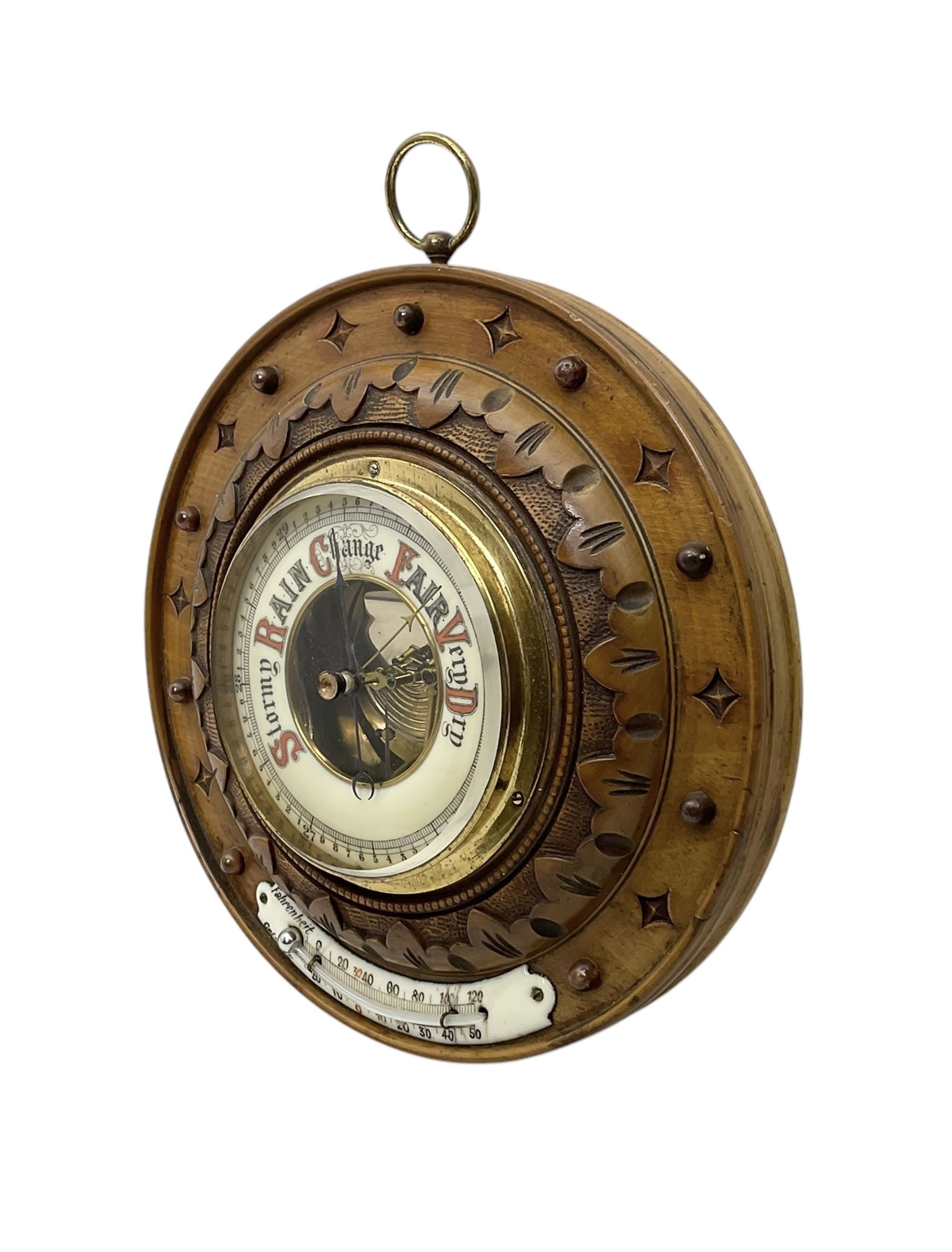 German- Late 19th century aneroid Barometer in a carved mahogany case with pendants and finials, 4” open dial register and mercury thermometer, with another early Edwardian aneroid barometer in a circular carved  walnut case with a 4