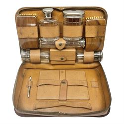 Mappin & Webb leather cased campaign gentleman's vanity set, the tan leather case opening to reveal fitted interior with five engine turned silver capped glass vanity bottles, hallmarked Mappin & Webb, London 1944, brushes, mirror etc, monogram DPK to the top of the case