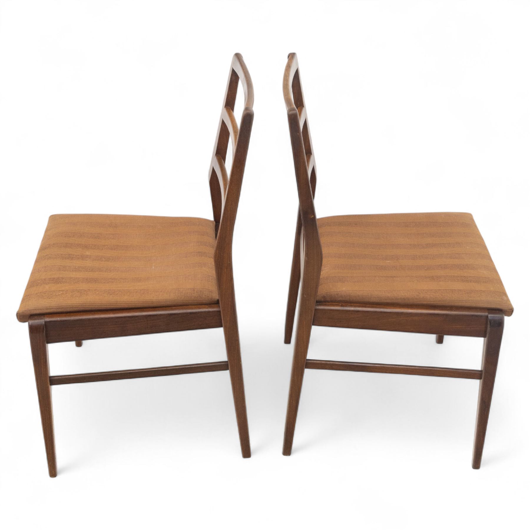 Richard Hornby for Fyne Ladye - mid-20th century afromosia teak dining table, tapered rectangular top with fluted edge and recess for spare leaf, raised on slender legs, four teak framed chairs, of ladder back design, with drop-in seat, upholstered seat, with tapered front legs and slightly raked rear legs,, table unextended width 106cm depth 79cm height 74cm with additional leaf 45cm wide- chairs width 48cm depth 41cm height 87cm 