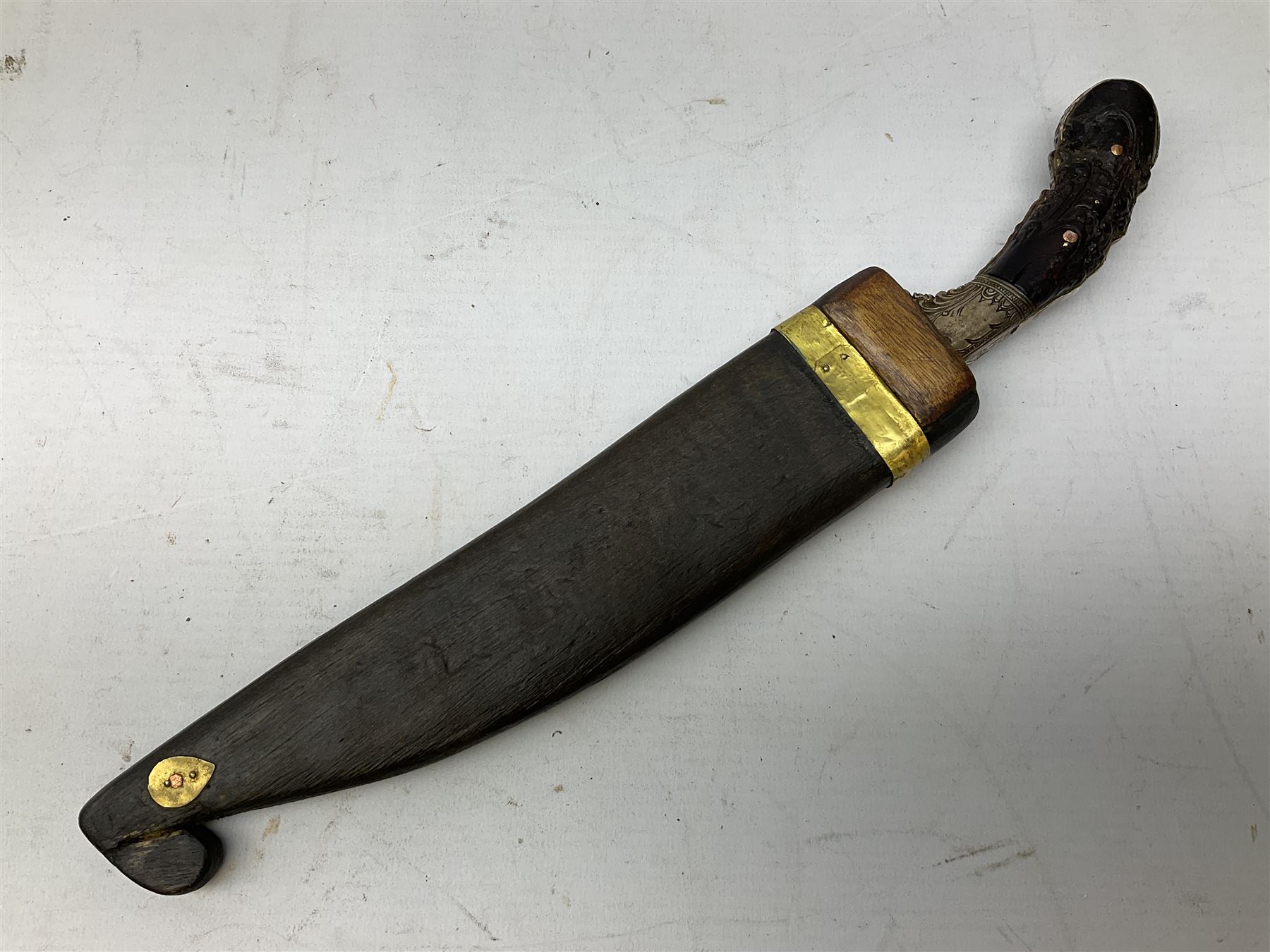 19th century Singhalese knife pia kaetta, the 20cm steel blade inset with yellow and white metal, with metal mounted carved pistol grip, in plain wooden scabbard L33cm overall