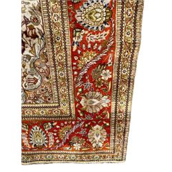 Persian Kashan, scalloped central medallion on indigo ground field, decorated profusely with branch shoots with floral motifs, pale ground spandrels decorated with stylised flower head motifs, crimson ground border decorated with repeating palmettes and trailing leafy branches, within multiple guard stripes 