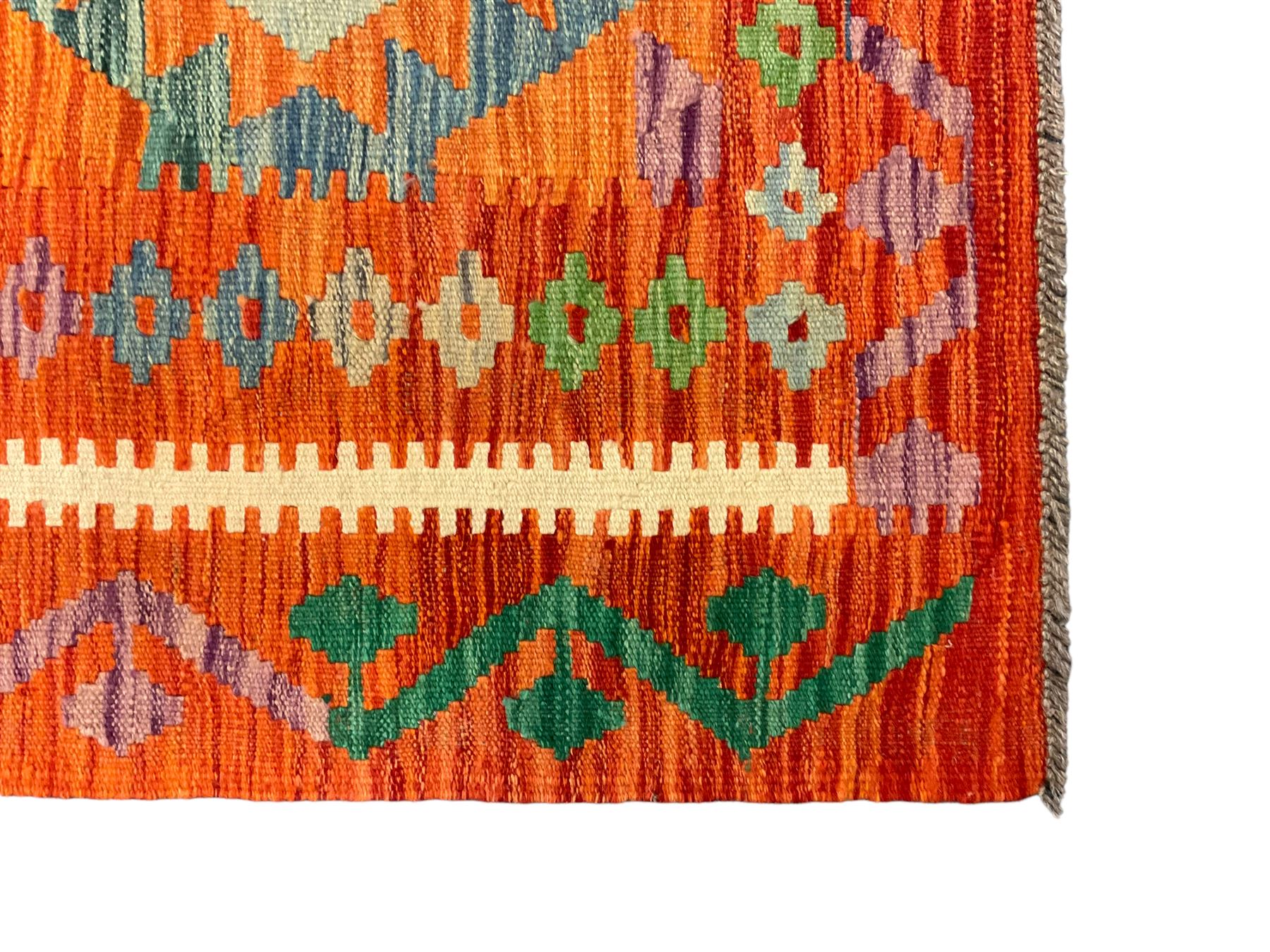 Anatolian Turkish Kilim amber ground rug, the field decorated with four lozenges with ivory outline, the double banded orange border with repeating geometric patterns 