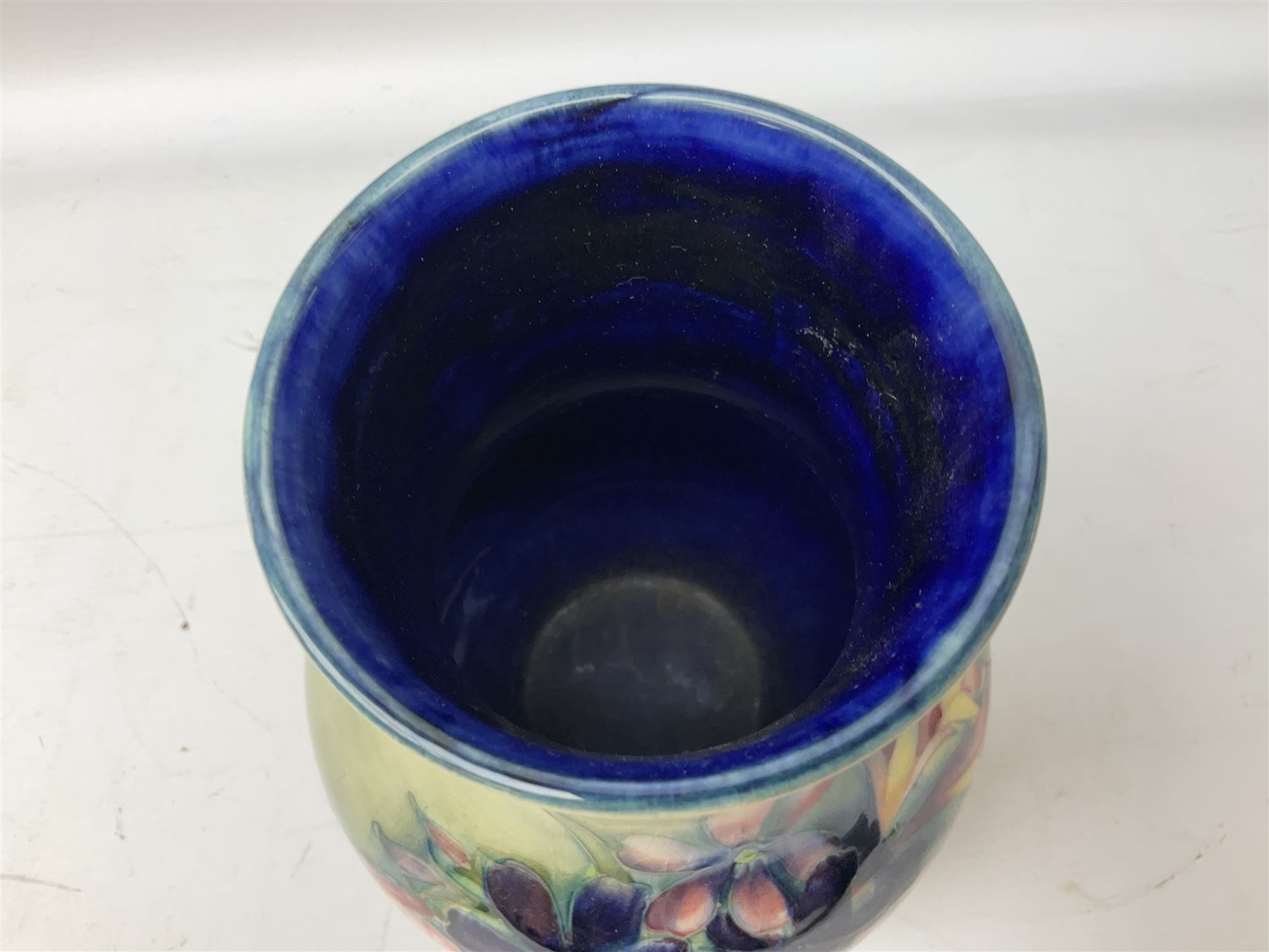 Moorcroft vase of baluster form decorated in the Spring Flowers pattern upon a merging green and blue ground, with impressed and painted marks beneath, H22.5cm