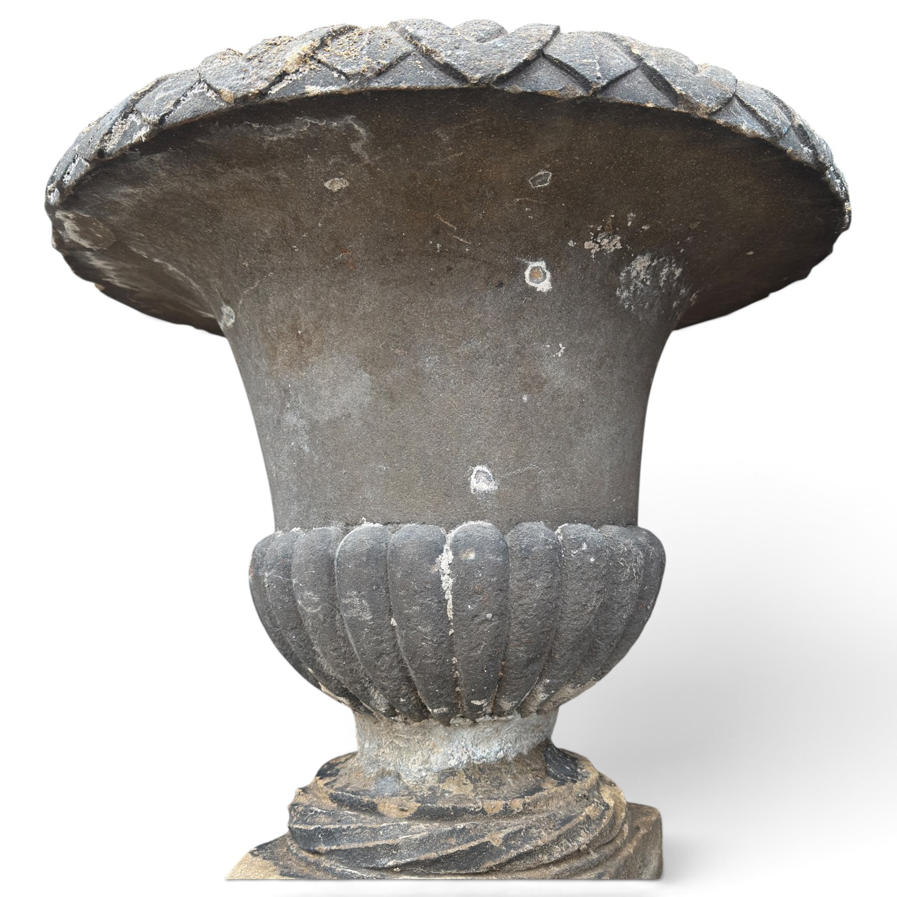 Set of three 19th century weathered carved sandstone garden urns of Neoclassical campana form, the broad everted rim carved with pointed egg-and-dart motifs, above a plain waisted bowl with gadrooned underbelly, on moulded rope-twist socle and square plinth base