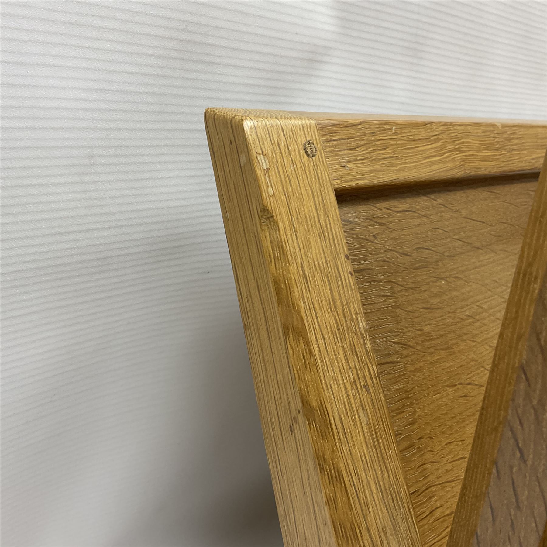 Mouseman - oak magazine rack, the top rail pierced with handle and carved with mouse signature, octagonal supports with two panelled and splayed sides, on sledge feet, by the workshop of Robert Thompson, Kilburn 