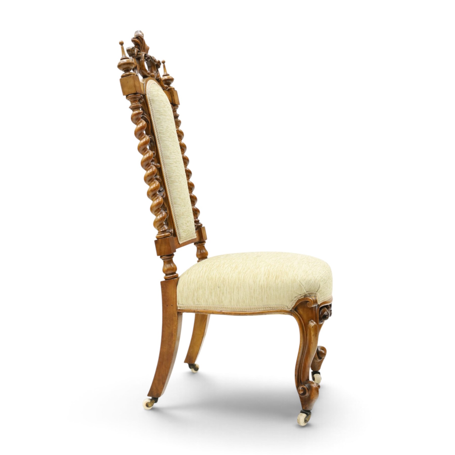 Victorian carved walnut side chair, the ornate high back with pierced and carved scrolled cartouche cresting rail, the back panel and sprung seat upholstered in sage green fabric, flanked by scrolling acanthus leaves and spiral turned pilasters, raised on scroll carved cabriole legs with ceramic castors