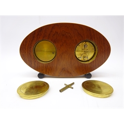  Early 20th century burr maple Weather Station, the clock and aneroid barometer with white enamel dials and central brass thermometer, oval section case on ebonised turned feet, H16cm, W26.5cm, D4cm  