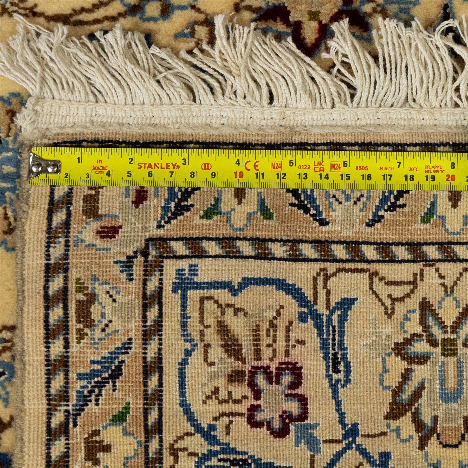 Central Persian fine Nain hand-knotted rug, ivory ground, with a central shaped floral medallion with pendants, surrounded by scrolling foliate and floral motifs incorporating rosettes, palmettes and delicate vine work in blue, cream and beige tones, enclosed by blue spandrels and an ivory border with repeating palmettes and meandering vines, flanked by floral guard stripes, with cotton fringes