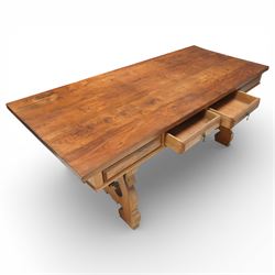 20th century Spanish design oak dining table, large rectangular top above a run of three drawers to the frieze, standing on shaped trestle supports with scroll cut details and stretcher base