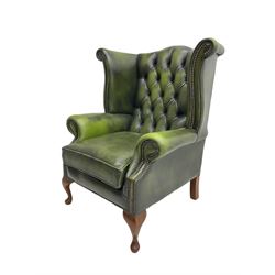 Georgian style wingback armchair, upholstered in buttoned green leather, on cabriole feet