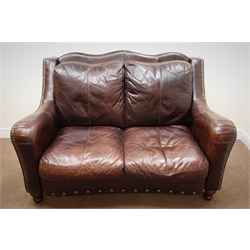  Two seat traditional sofa upholstered in brown studded leather, shaped back, serpentine front, turned supports, W158cm  