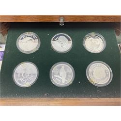 The Royal Mint 'Conservation Coin Collection' formed of twenty-four silver proof coins, housed in the wooden display case, with information booklet