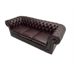 Thomas Lloyd - three seat Chesterfield sofa, upholstered in buttoned oxblood leather, on castors 