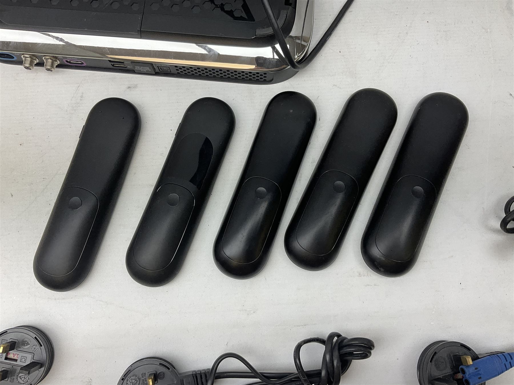 Sky Q box together with two mini room boxes with remotes and a quantity of remote controls and cables