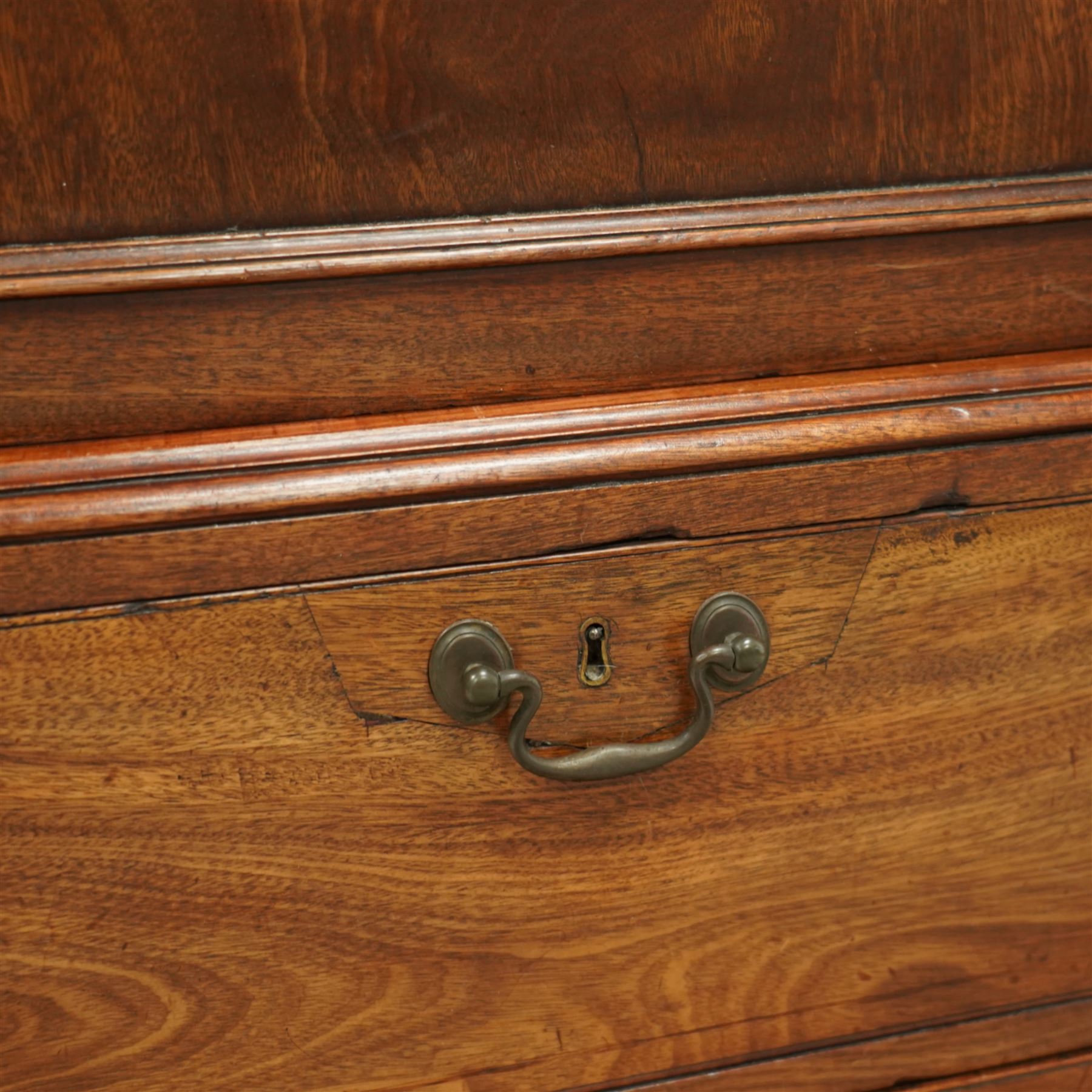 George III mahogany linen press, dentil moulded cornice over a pair of panelled doors enclosing a later fitted interior, lower section with two short over one long cockbeaded drawer, brass swan neck handles, shaped bracket feet
