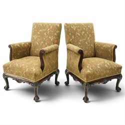 Pair of Chippendale design carved mahogany framed armchairs of stylised lyre form, high square backs and sprung seat upholstered in olive-ground foliate fabric, scrolled arm terminals with applied rosettes, the seat rail moulded with central scallop-and-acanthus motif, raised on shell-carved cabriole supports with ball-and-claw feet