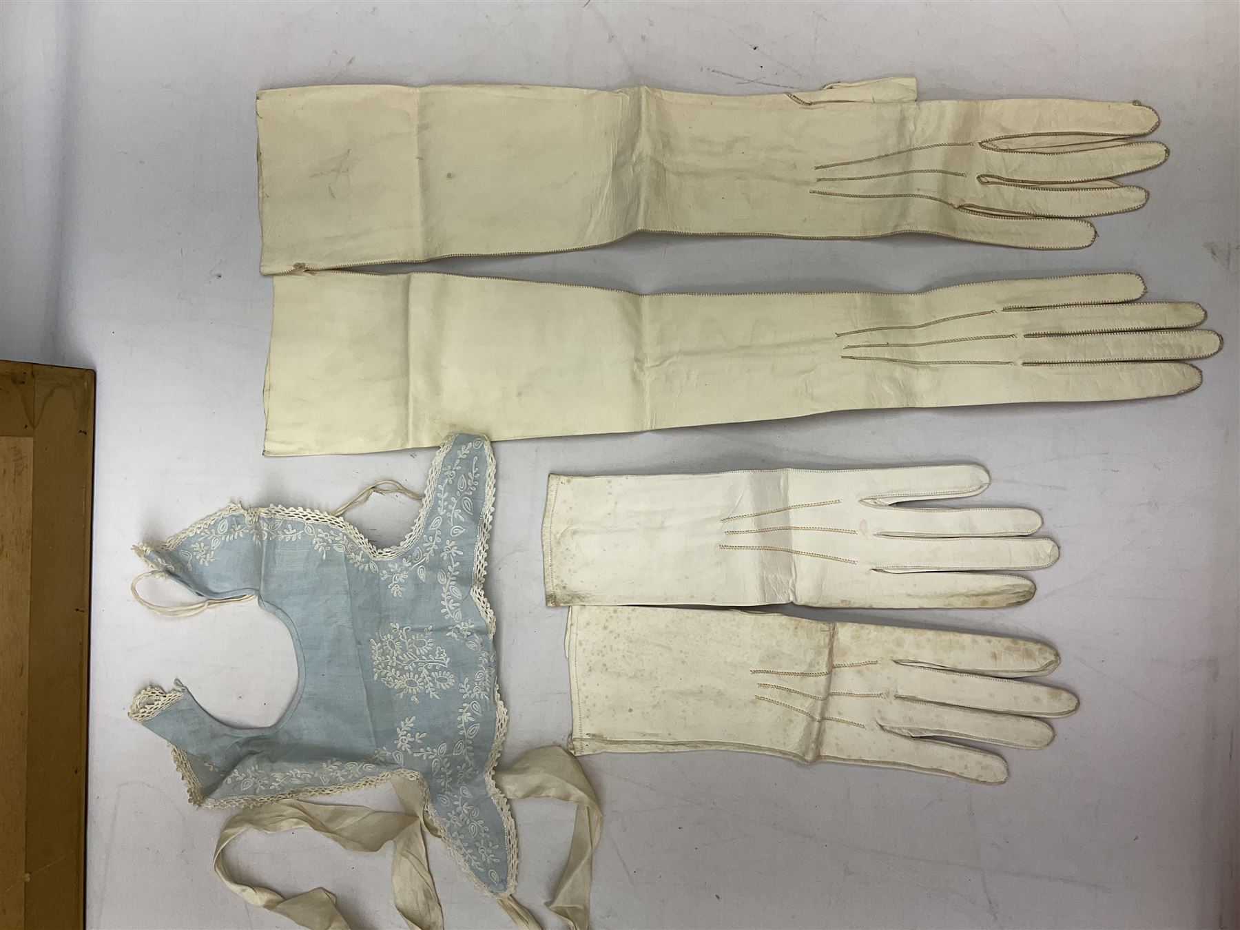 Late 18th century sampler worked with the alphabet above verses in red, by Mary Birkett aged 10 November 16th 1792, H33.5cm W34.5cm, together with another sampler worked with the alphabet above Proverbs 14:23, by Mary Anne Hainworth, Chesham, date unknown (--83), both in glazed frames, together with a quantity of Victorian and later dolls clothes to include lace examples