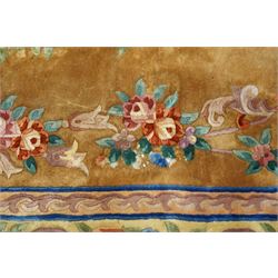 Chinese Aubusson/Savonnerie style hand-knotted carpet, ivory field with a central oval medallion issuing with stylized bouquets in shades of blush pink, pale blue, sage and green, enclosed by ribbon-tied floral garlands and conforming borders within narrow guard stripes, with cotton fringe ends 