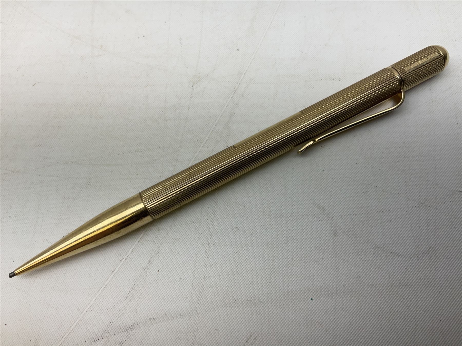 9ct gold propelling pencil with engine turned decoration and vacant cartouche, by S J Rose & Son, stamped 375, L12cm, together with a Parker 12ct rolled gold fountain pen, and two rose gold engine turned propelling pencils to include a rose gold example