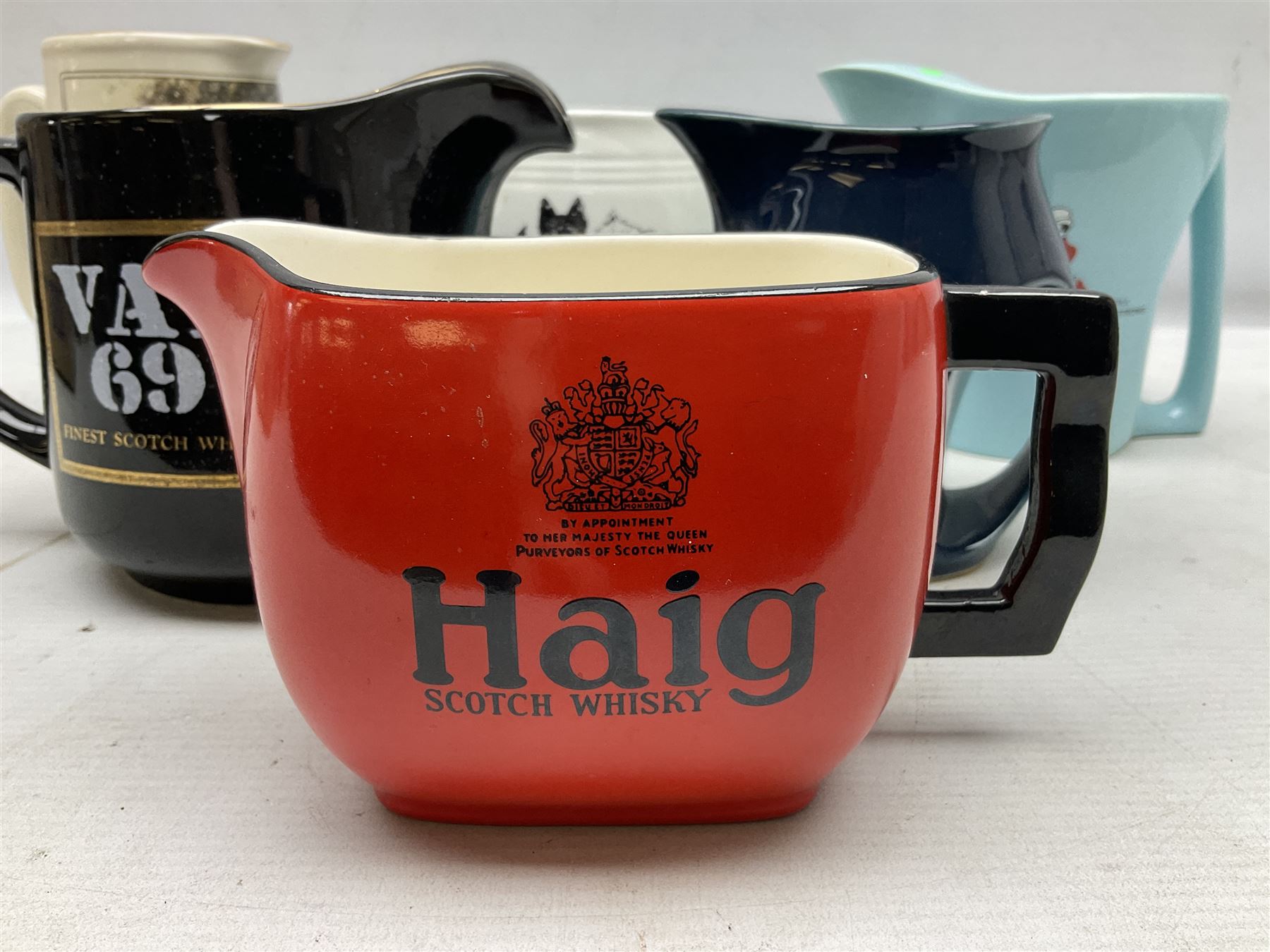 Six whisky water jugs, to include Wade Johnnie Walker, Haig, Black & White, etc