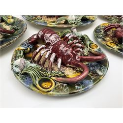 Five 20th Century Portuguese Palissy style Majolica wall plates, all depicting crustaceans to the centre modelled in relief surrounded by encrustations and shells, both with impress marks beneath, largest D29cm