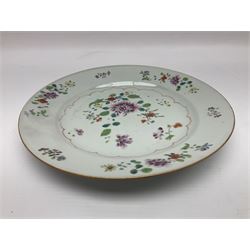 Three 18th century Chinese Famille Rose plates, the first example enamelled with blossoming peonies, rockwork and fence, the other two examples of similar design, decorated with blossoming peonies and sprigs within shaped inner borders, each approximately D23cm