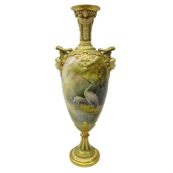  Royal Worcester porcelain twin handled pedestal vase, painted with two wading storks in a misty woodland landscape, signed by Arthur Lewis, within gilded acanthus leaf and scroll borders, mask handles below garland wreaths and scrolled panelled neck, shape number 1410, date code for 1909, H39cm   