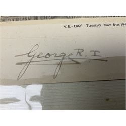 King George VI and Queen Elizabeth - the photograph and signatures only from a 1945 Christmas card depicting The Royal Family waving from the balcony of Buckingham Palace, on V-E Day Tuesday May 8th 1945, signed 'George R.I. Elizabeth R.'