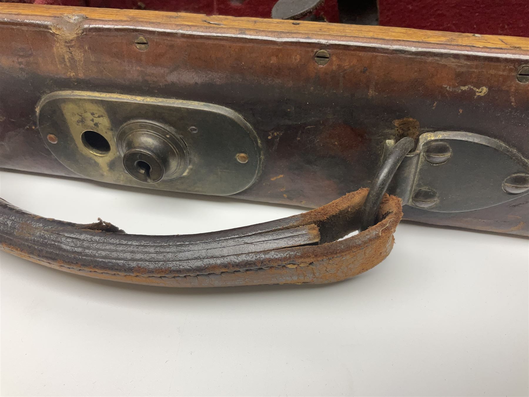 Leather shotgun case, the red baize lined interior with the trade labels of Westley Richards & Co., London, a brass plaque inscribed 'T Nevin, Mirfield, Yorkshire' to cover, with key, case to fit barrel 76cm (30 inches)  
