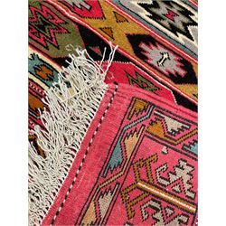 Persian red ground rug, the field divided into horizontal rows and decorated with geometric motifs, intricately pattern borders and end panels