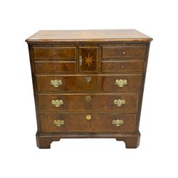 Late 20th century walnut veneered television chest in Georgian style, rectangular top over simulated drawer front with central marquetry star inlay, opening to a shelved TV compartment, lower section fitted with one long drawer, brass handles and ogee bracket feet