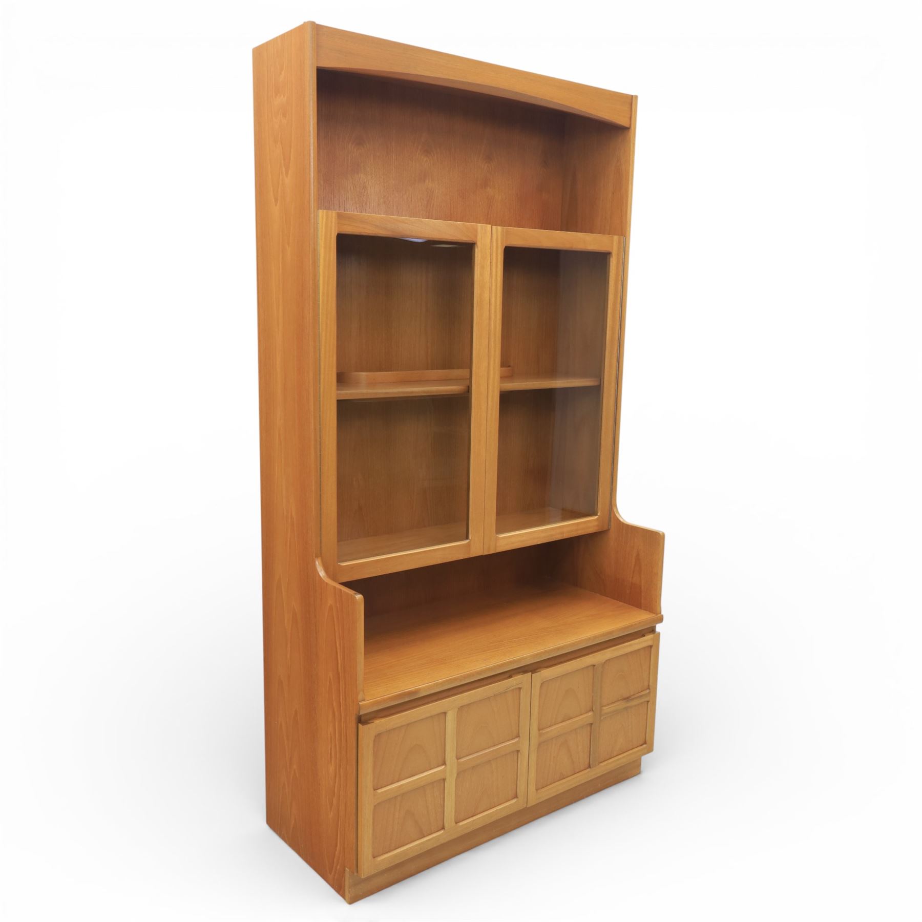 Nathan - teak wall unit, the arched open display recess above a glazed cabinet enclosed by two cupboard doors fitted with internal shelving, the lower section with a recessed serving surface over a pair of signature square panelled cupboard, raised on an integrated plinth base